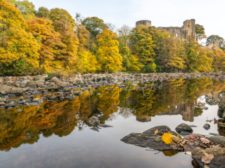 Barnard Castle reflected in the still waters of the river tees