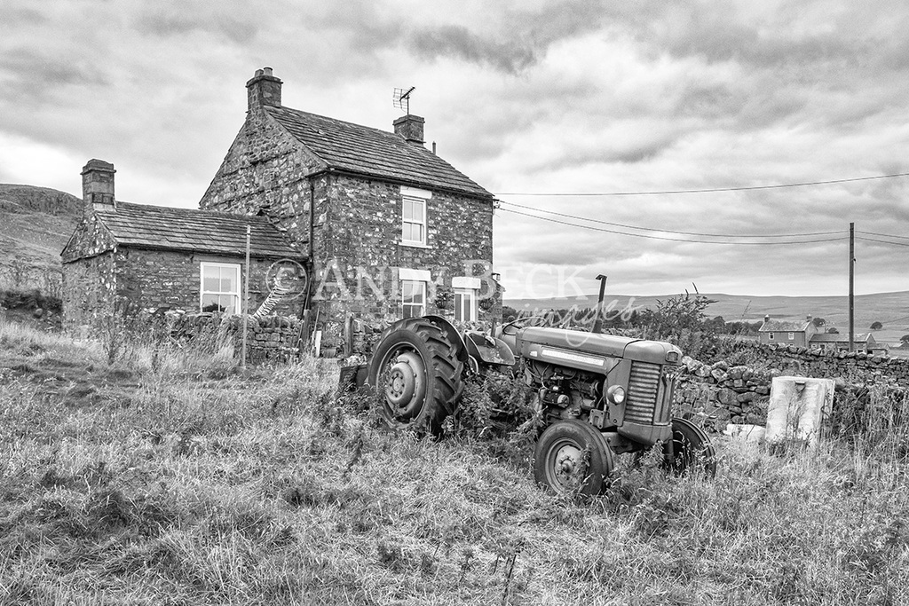 In retirement, black and white photo of a tractor and a cottage in Teesdale