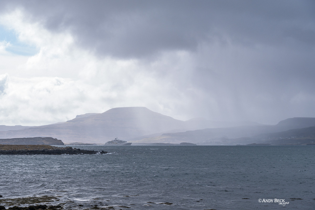 Rain over a cruise ship in Loch Dunvegan with Macleod's Tables behind. Isle of Skye