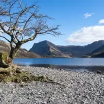 The shore of Buttermere Lake with Fleetwith Pike and Haystacks in the distance